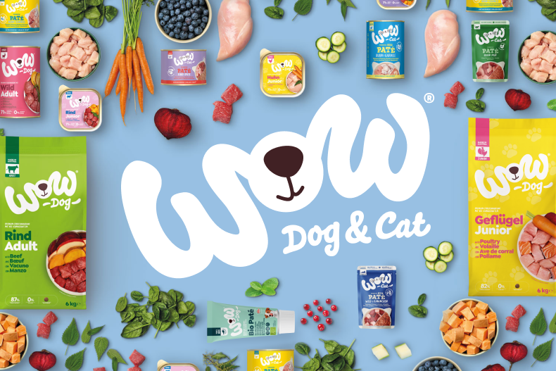 WOW Dog & Cat Aktionsbanner für Hunde‑ und Katzenfutter von WOW. Verschiedene Produkte wie Trocken‑ und Nassfutter sowie Zutaten wie Gemüse und Fleisch sind rund um ein großes WOW‑Logo angeordnet, Hinweis auf natürliches Sortiment für Hunde und Katzen.